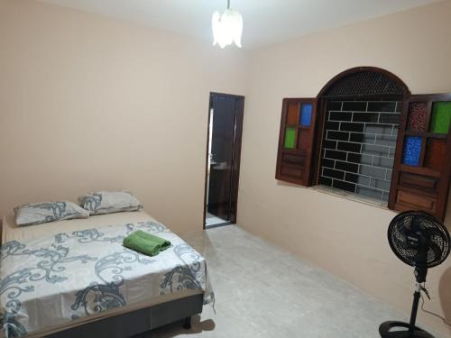 1 dormitorio con 1 cama, ventana y ventilador en House Matarazzo, en Feira de Santana