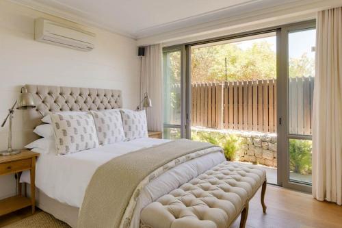una camera da letto con un letto grande e una grande finestra di Bungalow Kloof a Città del Capo