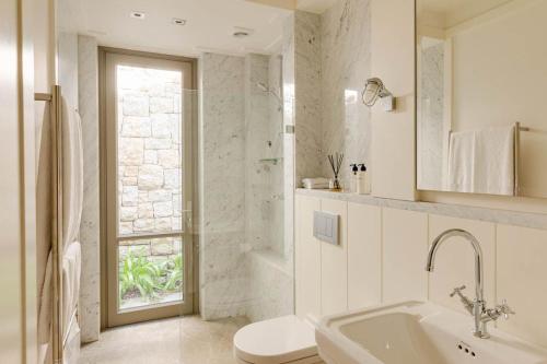 un bagno bianco con lavandino e WC di Bungalow Kloof a Città del Capo