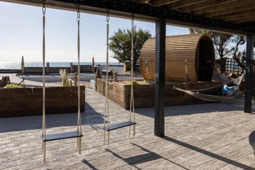 a swing in a pavilion with a hammock at Luxury Seafront Family Home - Indoor Pool in Earnley