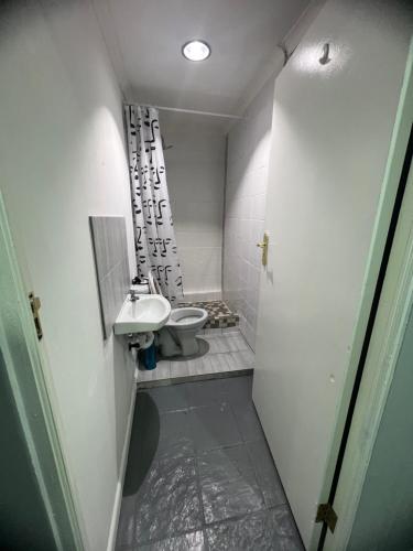 a small bathroom with a toilet and a sink at M and B MotherCity Backpackers in Cape Town