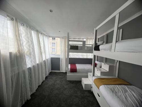 a bedroom with two bunk beds and a window at M and B MotherCity Backpackers in Cape Town