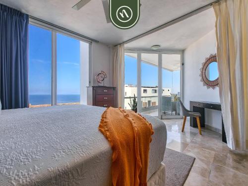a bedroom with a bed and a view of the ocean at Corner 2 BR Condo - Spectacular Oceanview Sunsets in Puerto Vallarta