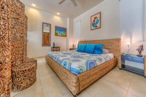 a bedroom with a wicker bed and a chair at Chic Studio -Rooftop Pool - Ocean View - King Bed in Puerto Vallarta