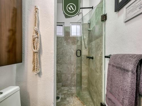 a bathroom with a shower with a glass door at Corner 2 BR Condo - Spectacular Oceanview Sunsets in Puerto Vallarta