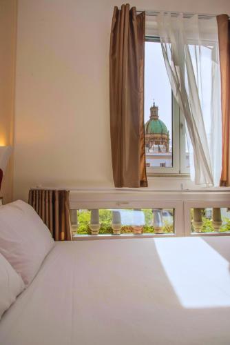 a bedroom with a bed and a window at Suites Cavour holiday dream in Palermo