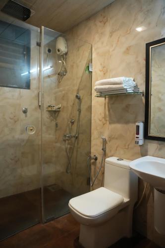 a bathroom with a shower and a toilet and a sink at Rio Royale in Bhimashankar