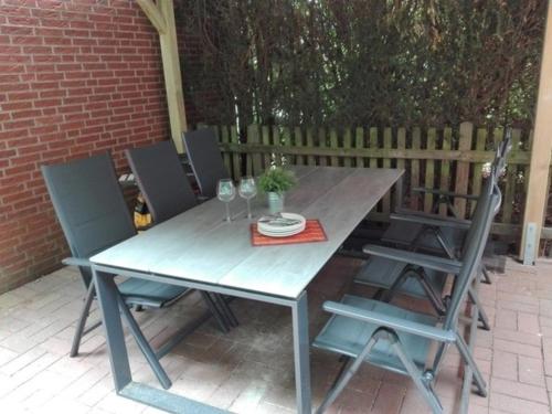 Una mesa y sillas de madera en un patio. en Schwedenhaus RE25, en Sögel
