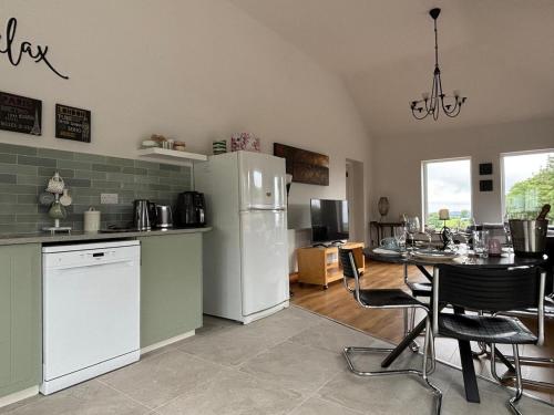 a kitchen with a table and a white refrigerator at apartment cavan in Cavan