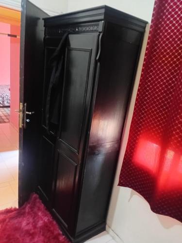 カサブランカにあるBelle chambre pour 2 sidi maaroufのベッドの隣の部屋にある黒いキャビネット