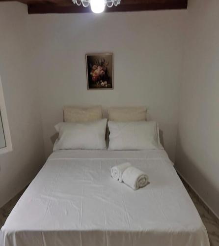 een wit bed met twee handdoeken erop bij Cabaña jenny in Tovar