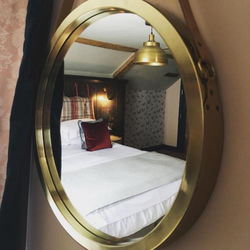 a bedroom with a bed and a mirror at The Stag at Stow in Stow on the Wold