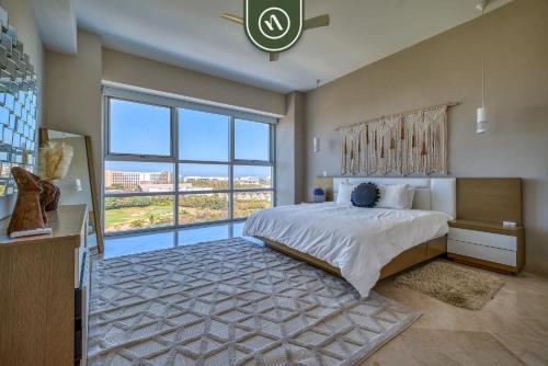 a bedroom with a large bed and a large window at Amazing 2BR Condo with Pool and Access to VIDANTA in Jarretadera