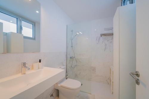 a bathroom with a shower and a toilet and a sink at CHL Naos del Mar, bright and modern apartment in Puerto Naos in Puerto Naos