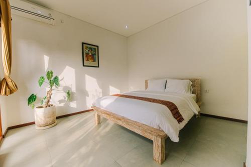 a bedroom with a bed and a potted plant at Villa Richard 5mins to Seseh Beach in Munggu