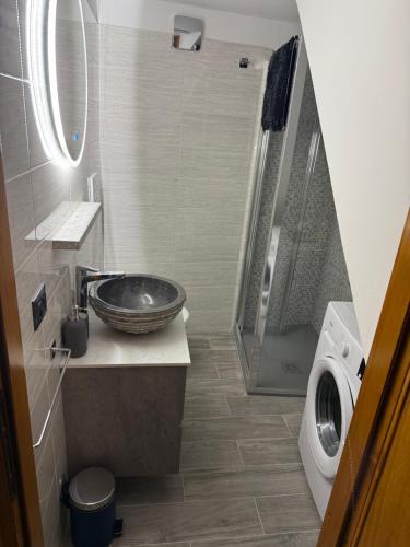 a bathroom with a sink and a washing machine at Stone Nest Lanzada in Lanzada