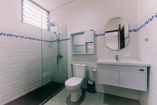 a bathroom with a toilet and a sink and a mirror at Villa Richard 5mins to Seseh Beach in Munggu