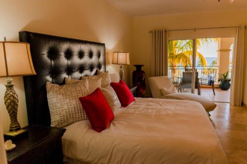 ein Schlafzimmer mit einem großen Bett mit roten Kissen in der Unterkunft Las Mañanitas LM E3402 in San José del Cabo