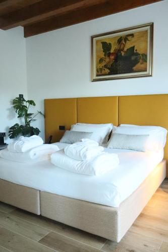 a large bed with white pillows on top of it at Tenuta Tommasi - Relais Bacco in Caorle