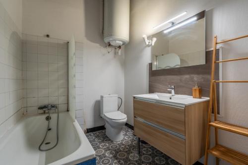 a bathroom with a tub and a toilet and a sink at Le nid des rois - Terrasse en hyper centre in Blois