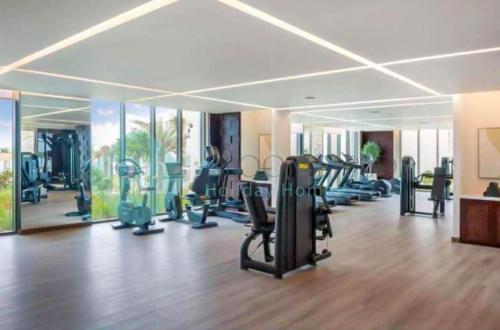 a gym with treadmills and ellipticals in a room at Beach Resort Address Luxury 2BR with Maid Sea View in Fujairah