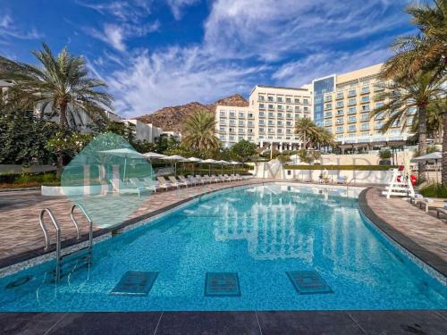 a large swimming pool in front of a hotel at Beach Resort Address Luxury 2BR with Maid Sea View in Fujairah