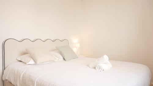 una cama blanca con sábanas y almohadas blancas en OPARADI 'Le Vert d'Opale I' L'escapade idéale à Le Portel, en Le Portel