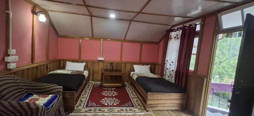 a small room with two beds in it at Welcome homestay in Pemayangtse