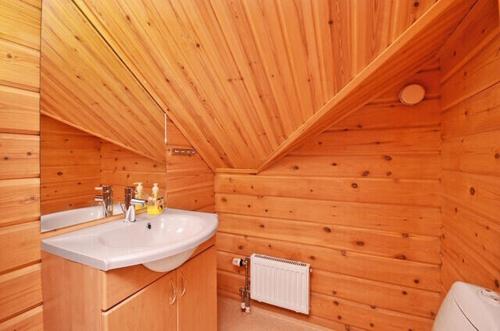 a bathroom with a sink and a wooden wall at Arctic shaman village -Jurtta in Rautuskylä