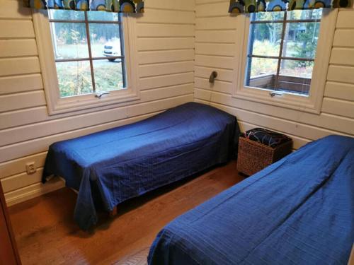 a bedroom with two beds and two windows at Arctic shaman village -Jurtta in Rautuskylä