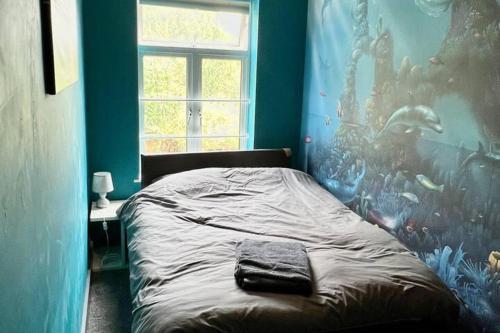 エガムにあるInviting 4-Bed House near Heathrow w Fireplaceのベッドルーム1室(魚の壁画が壁に施されたベッド1台付)