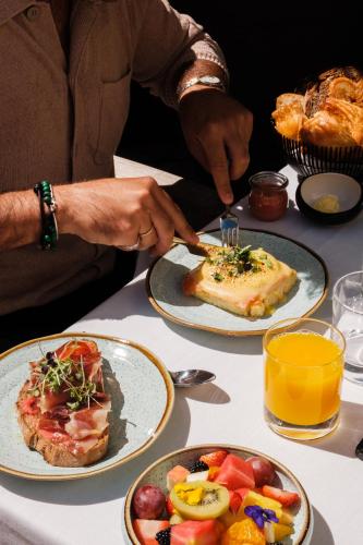 una persona cortando una rebanada de pizza en una mesa en CoolRooms Palacio Villapanés 5 GL, en Sevilla