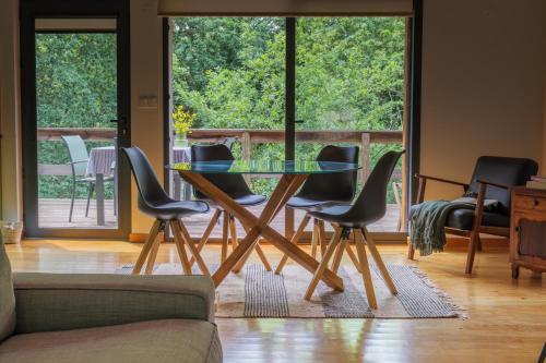 a glass table and chairs in a living room at Quinta da Fenteira - Casa Tora in Arcos de Valdevez