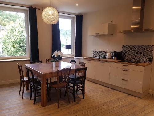 a kitchen with a wooden table and a table and chairs at Histoire d Ardenne in La Roche-en-Ardenne