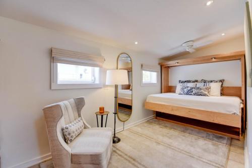a bedroom with a bed and a mirror and a chair at Slack Tide On Duval Street in Key West