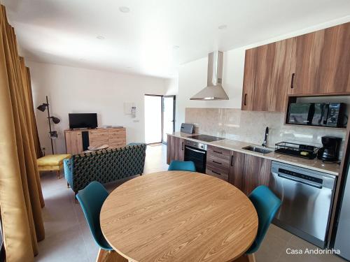 una cucina con un tavolo di legno e sedie blu di Casa Andorinha 