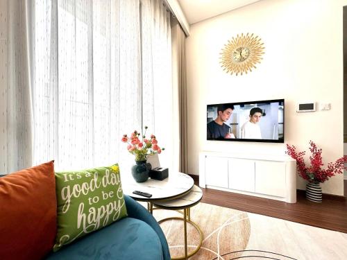 a living room with a blue couch and a tv at Masteri Pearl Apartment - Luxury view in Ocean Park 1 in Gia Lâm Pho