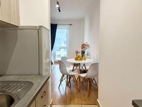 Una cocina con una mesa y sillas en una cocina. en Apartament Zagrodowa, en Oświęcim
