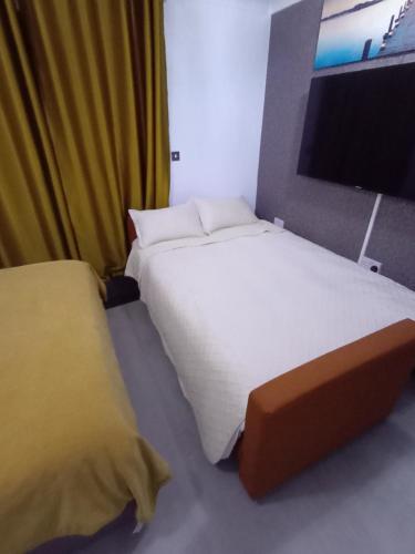 a bedroom with two beds and a flat screen tv at Bavelle Bilston Urban Village in Bilston