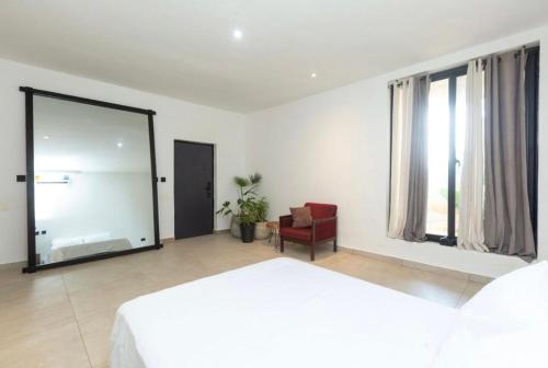 Un dormitorio con una gran cama blanca y una silla roja. en Pks Premium Apartment, en Nopendaw