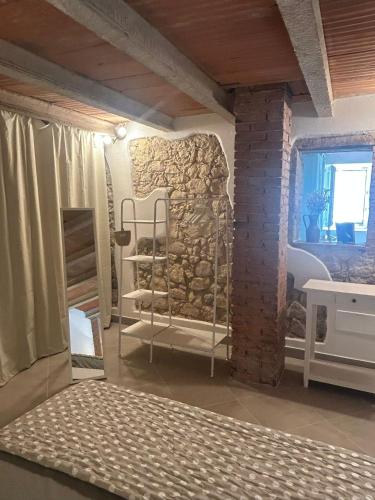 a room with a bed and a stone wall at Corte Ponte Verde in Montorio Veronese