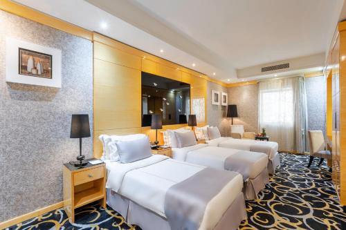 a hotel room with four beds in a room at Royal Majestic Hotel Makkah in Mecca