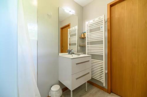 a white bathroom with a sink and a mirror at Chalet SOL LA MI in Soultzeren