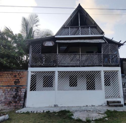 a white building with a black roof at Chalé Maison Blanche in Maracanã