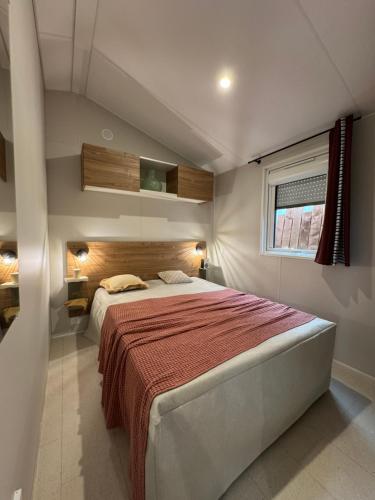 a bedroom with a large bed with a red blanket at Camping Le Royan in Royan