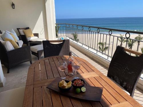a table with wine glasses and a bowl of fruit on a balcony at Tortuga Bay TBB 2502 in San José del Cabo