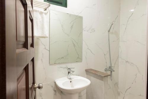 a white bathroom with a sink and a mirror at Atana Saigon Boutique Hotel II in Ho Chi Minh City