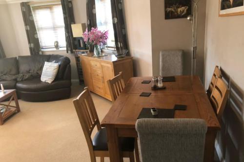 a living room with a wooden table and chairs at 1 Bedroom Apartment Sleeps 2 - Pets Welcome - Tv in Copthorne