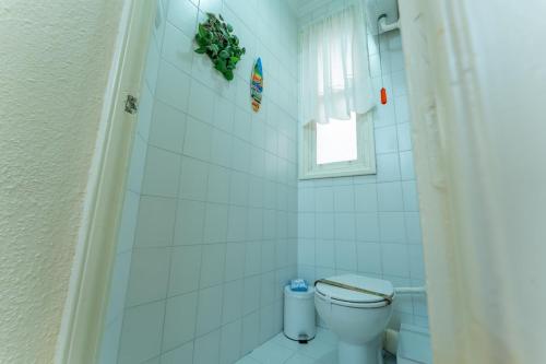 a bathroom with a toilet and a window at Tu refugio luminoso en el corazón de Santander in Santander