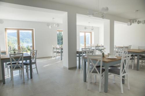 Un comedor con mesas y sillas y ventanas. en Nad Jeziorem, en Rożnów